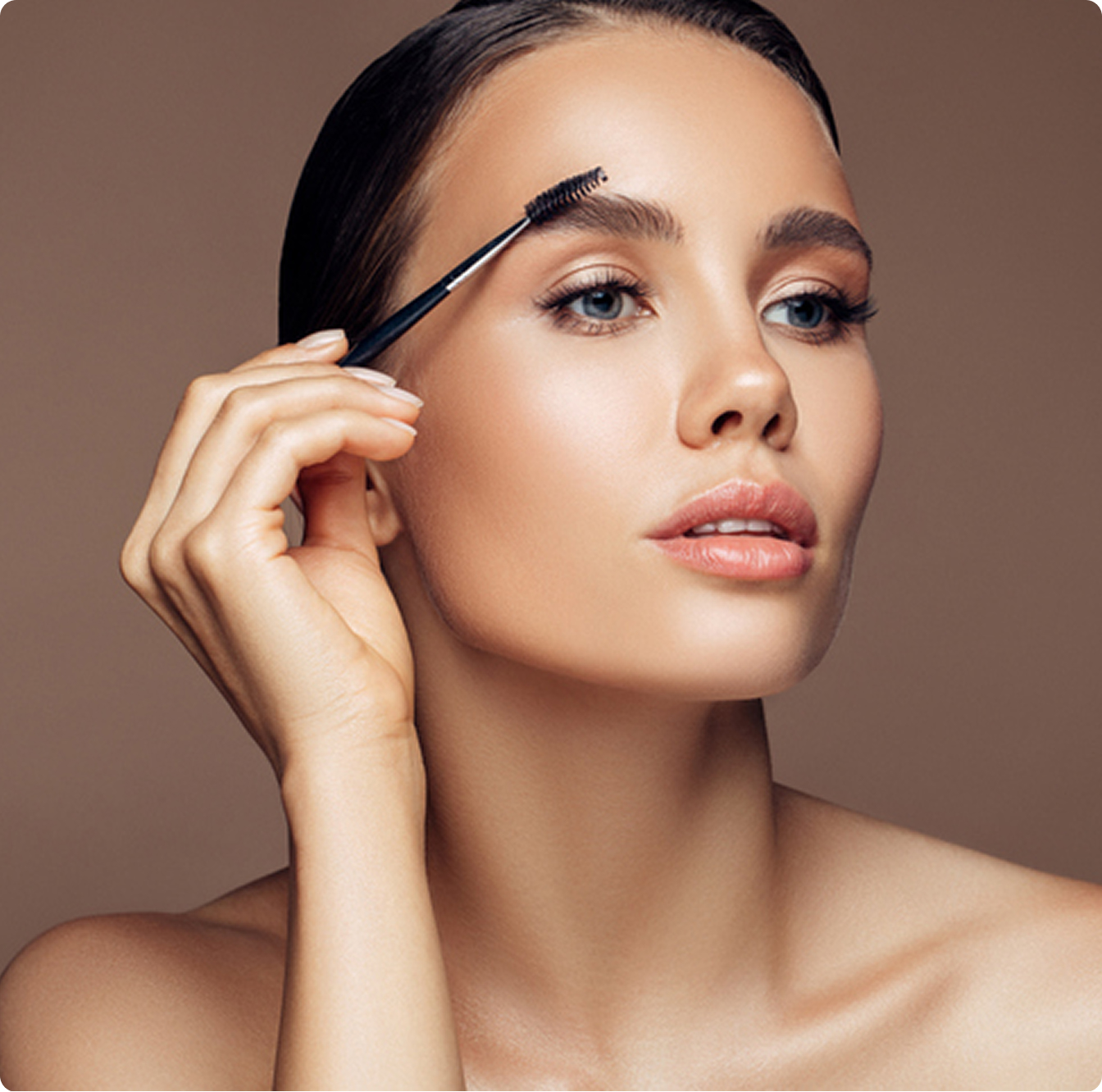 Woman grooming eyebrows with brush