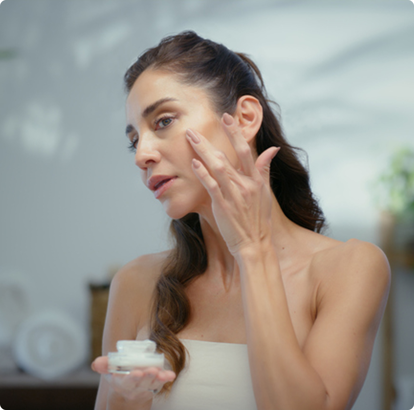 Woman applying facial cream