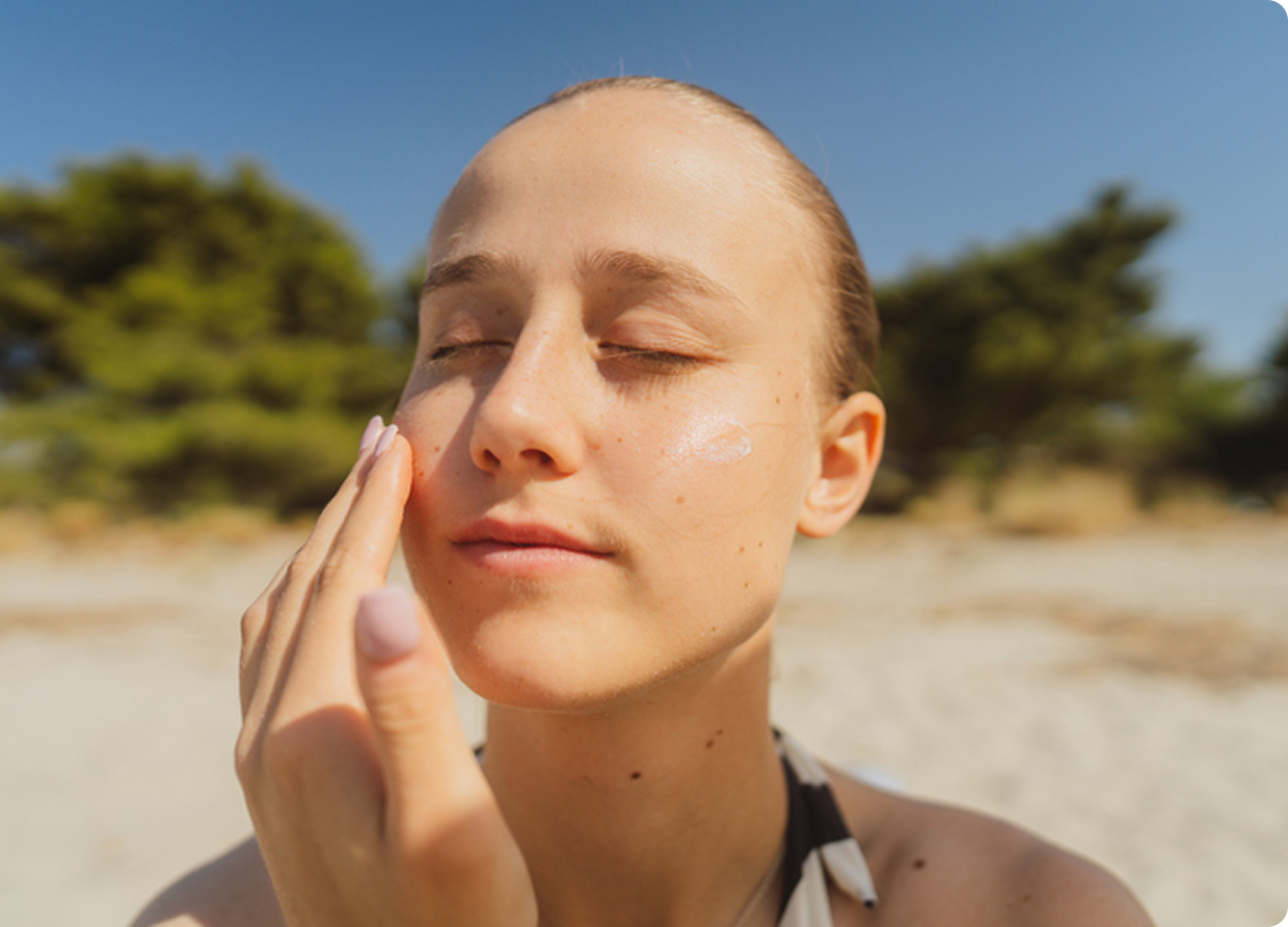 Woman applying sunscreen at the beach