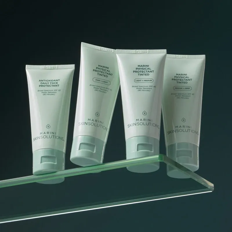 Skincare tubes on a glass shelf