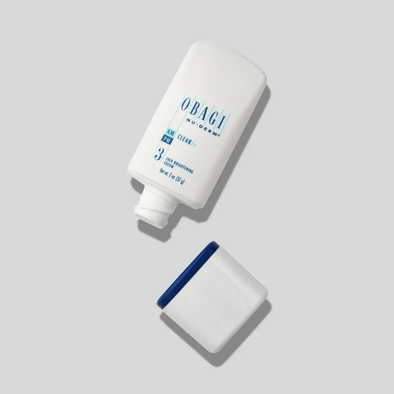 Skincare product bottle and cap on gray background.