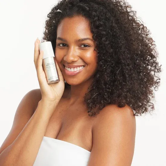 Curly-haired woman with beauty serum